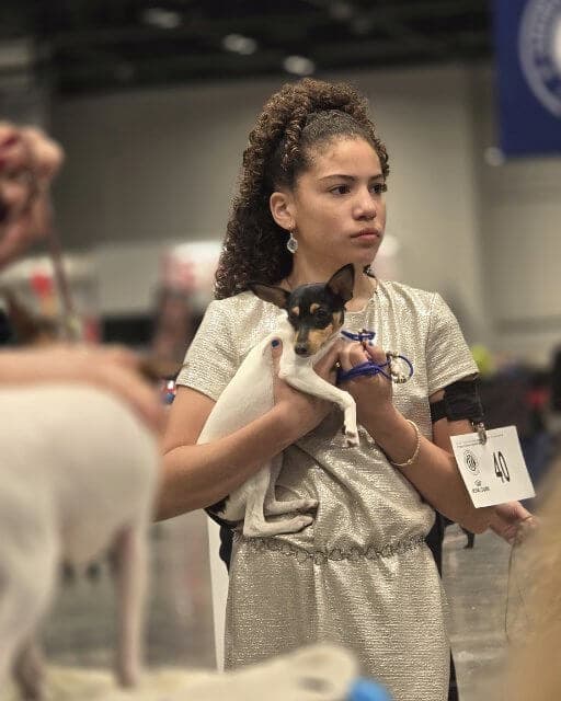 Ava Silva holding a small dog in her arms.