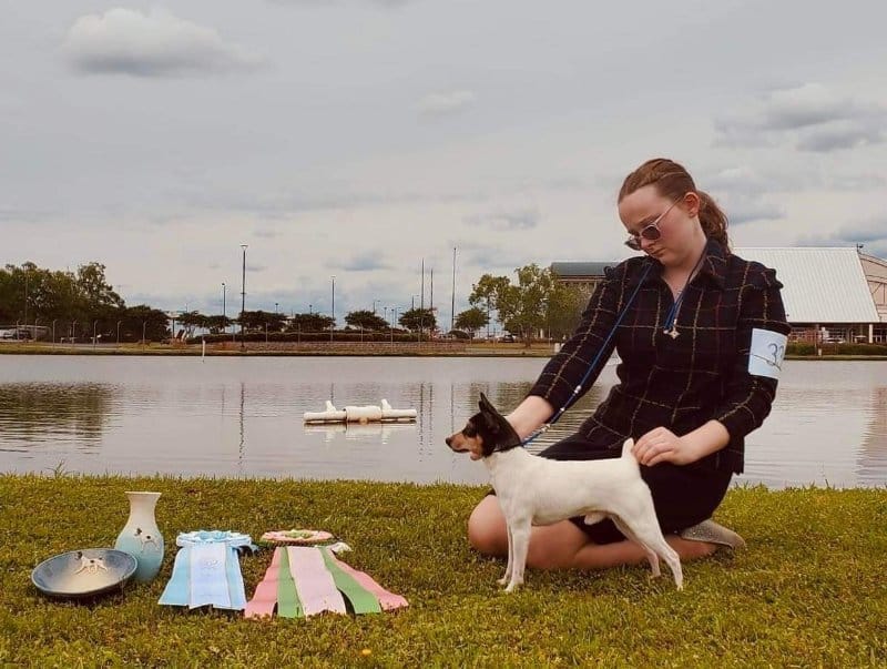 Alessandra Wagner with her Toy Fox Terrier dog, with accolades they won beside them
