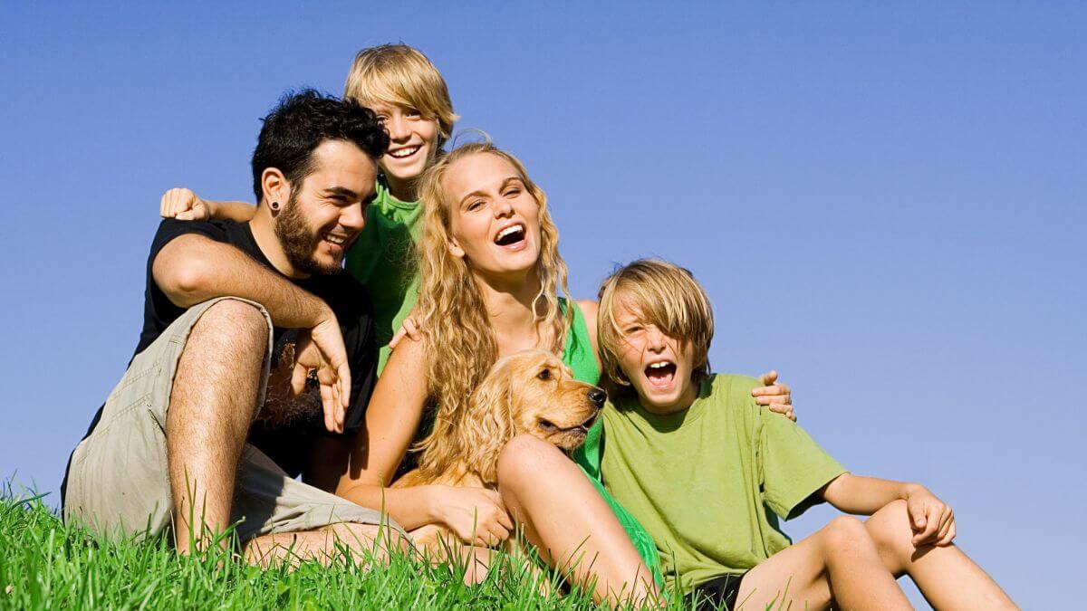 Happy healthy smiling loving young family fun with pet dog