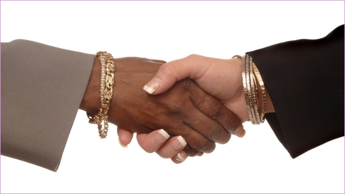 Women in Business. Two women shaking hands on a white background: one caucasian and one African American