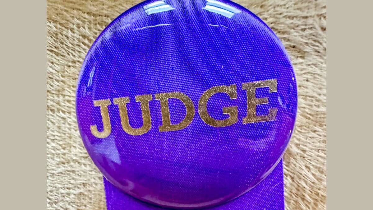 Purple badge with a Judge written on it