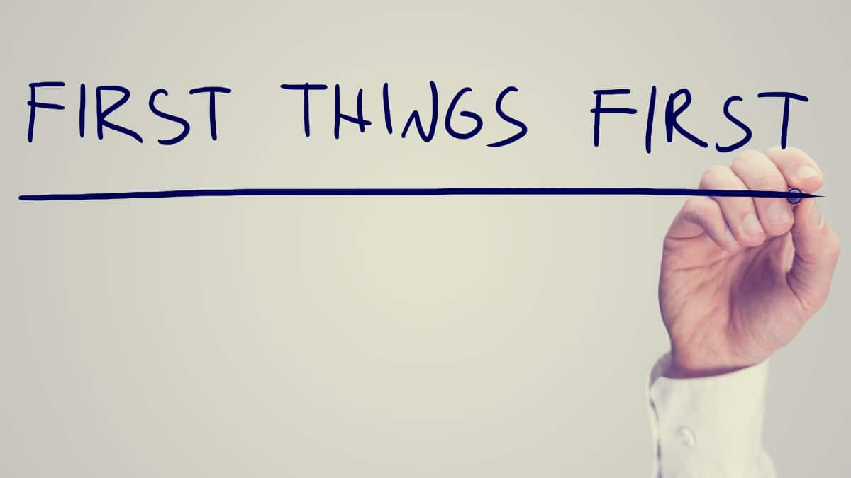 Retro effect concept - First Things First - with a man writing the words on a virtual interface with a marker pen over white with copyspace conceptual of prioritizing tasks.