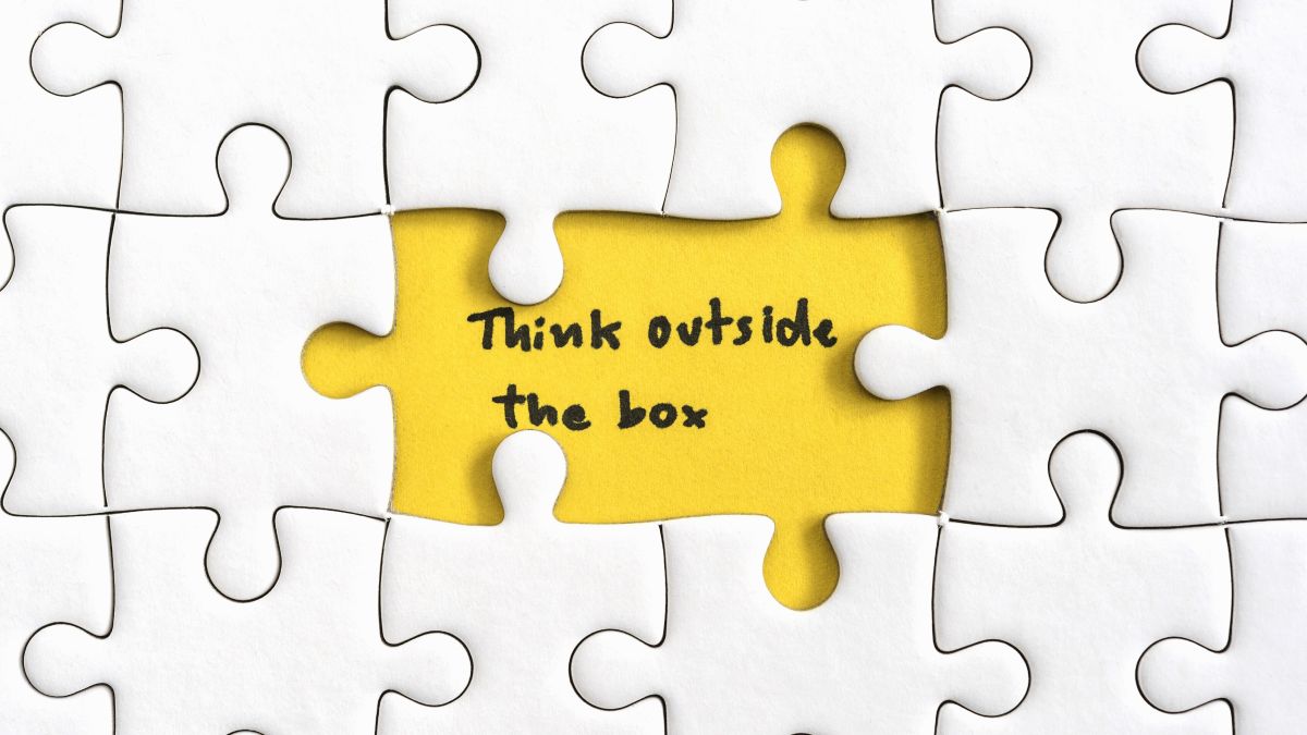Think outside the box quotes business concept. Jigsaw puzzle piece with two missing and hand writing letters word think outside the box, Quotes business concept