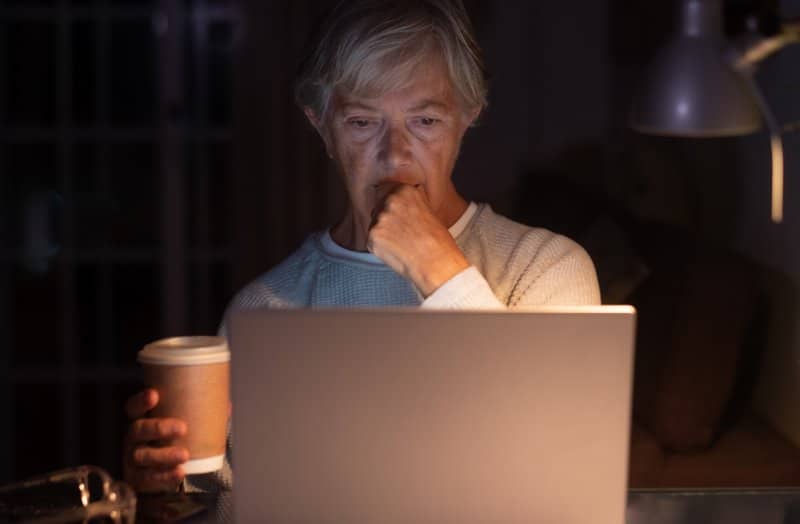 Elderly woman browsing social media content at night