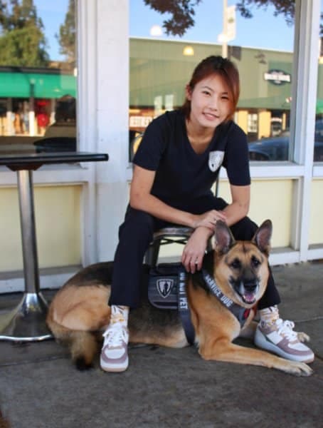 Asia Duhamel sitting on a chair with her Service Dog, German Shepherd known as "Lotus"