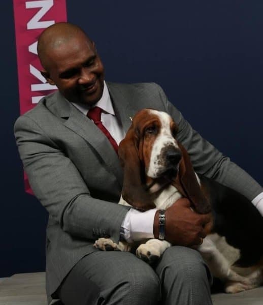 Man sitting with a Basset Hound dog