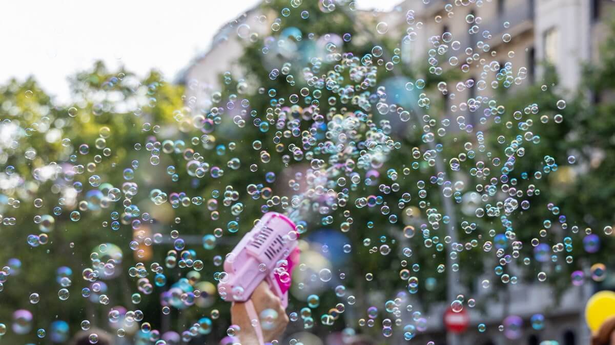 Colorful bubbles float around as people enjoy a lively celebration.