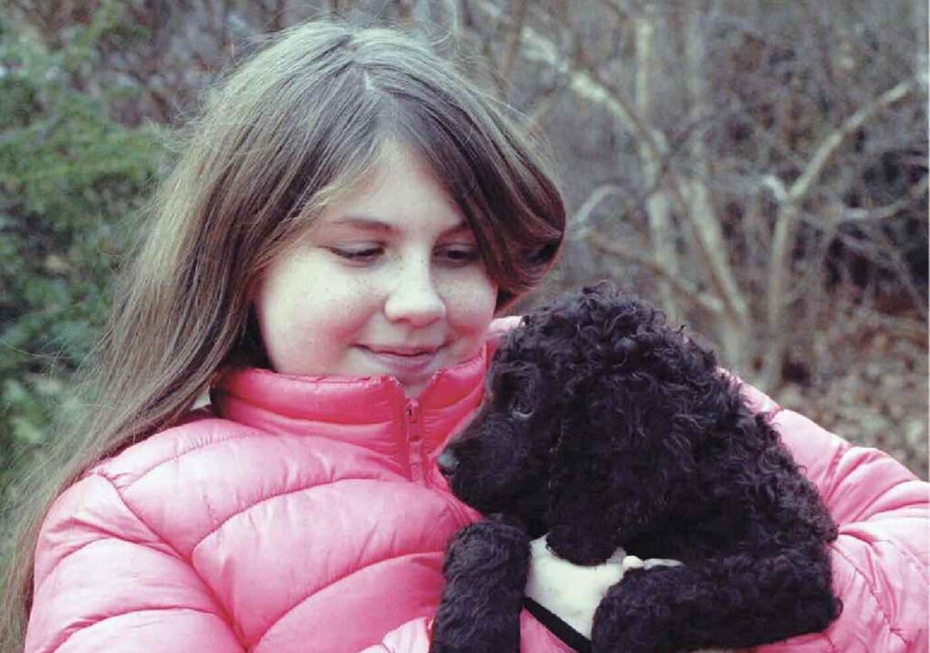 Breed Appeal - young girl holding a black puppy