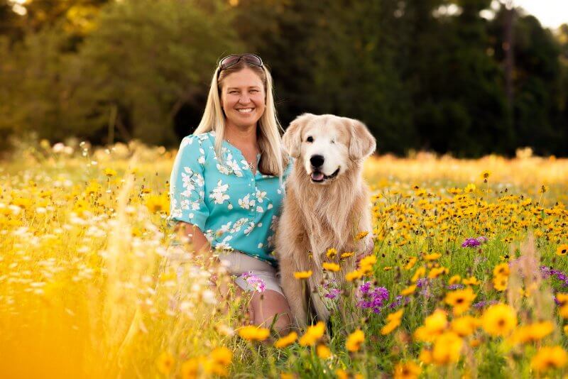 woman with her golden retriever in a field