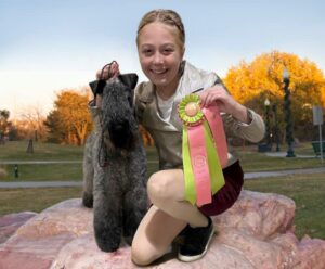 Averi Grier and her Kerry Blue Terrier on a rock