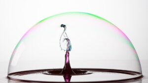 Splash of colorful liquid into a bubble with high speed flash