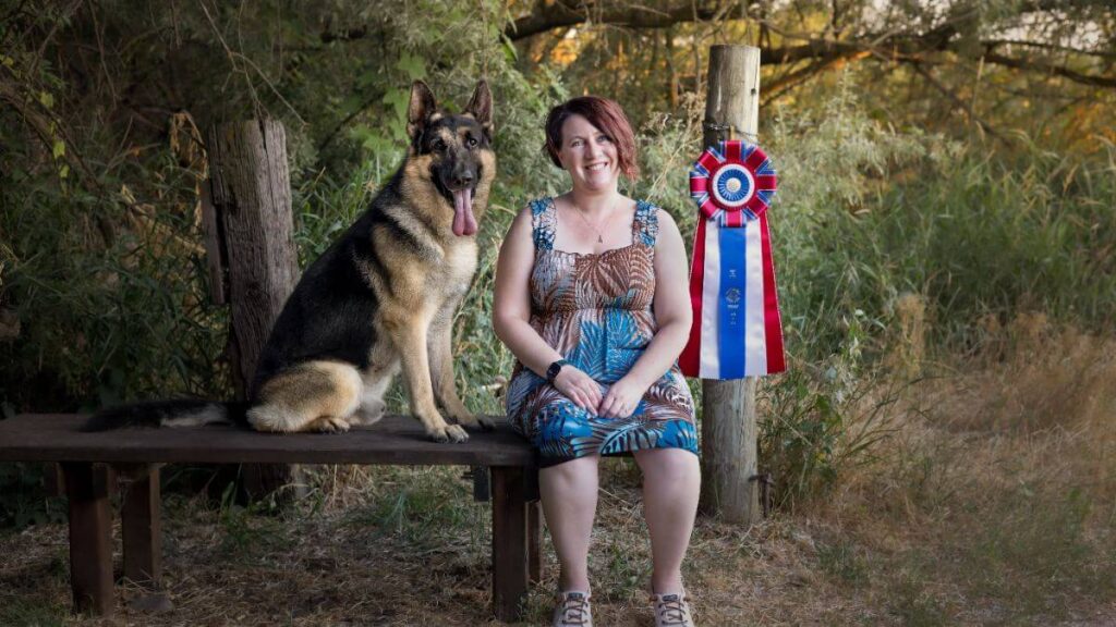 Veronica Dollar sitting on a bench with her German Shepherd