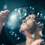 Thoughtful man alone wrapped in soap bubbles