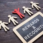 Plate with Rewards and recognition words and wooden employee figures.