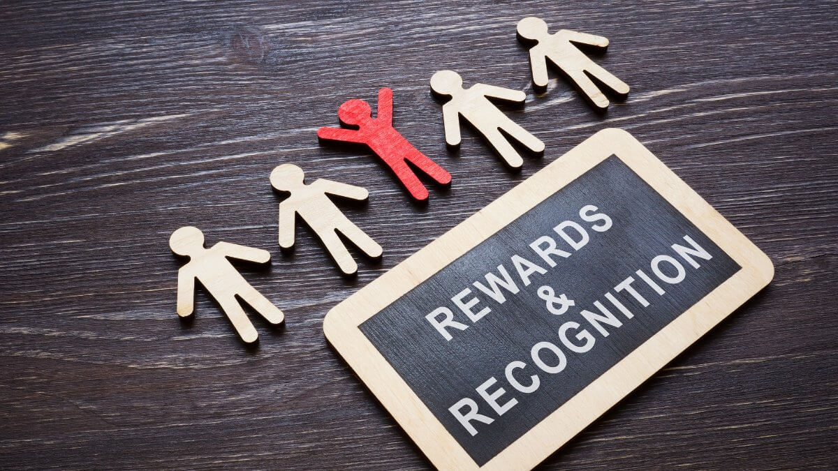 Plate with Rewards and recognition words and wooden employee figures.