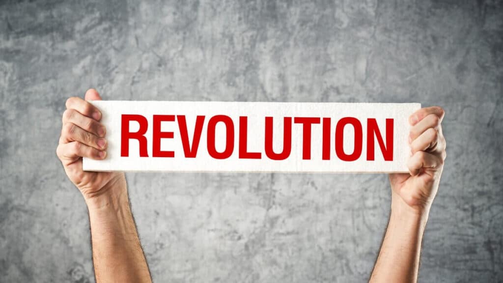 Man holding white banner with revolution title printed on it.