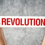 Man holding white banner with revolution title printed on it.