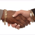 Women in Business. Two women shaking hands on a white background: one caucasian and one African American