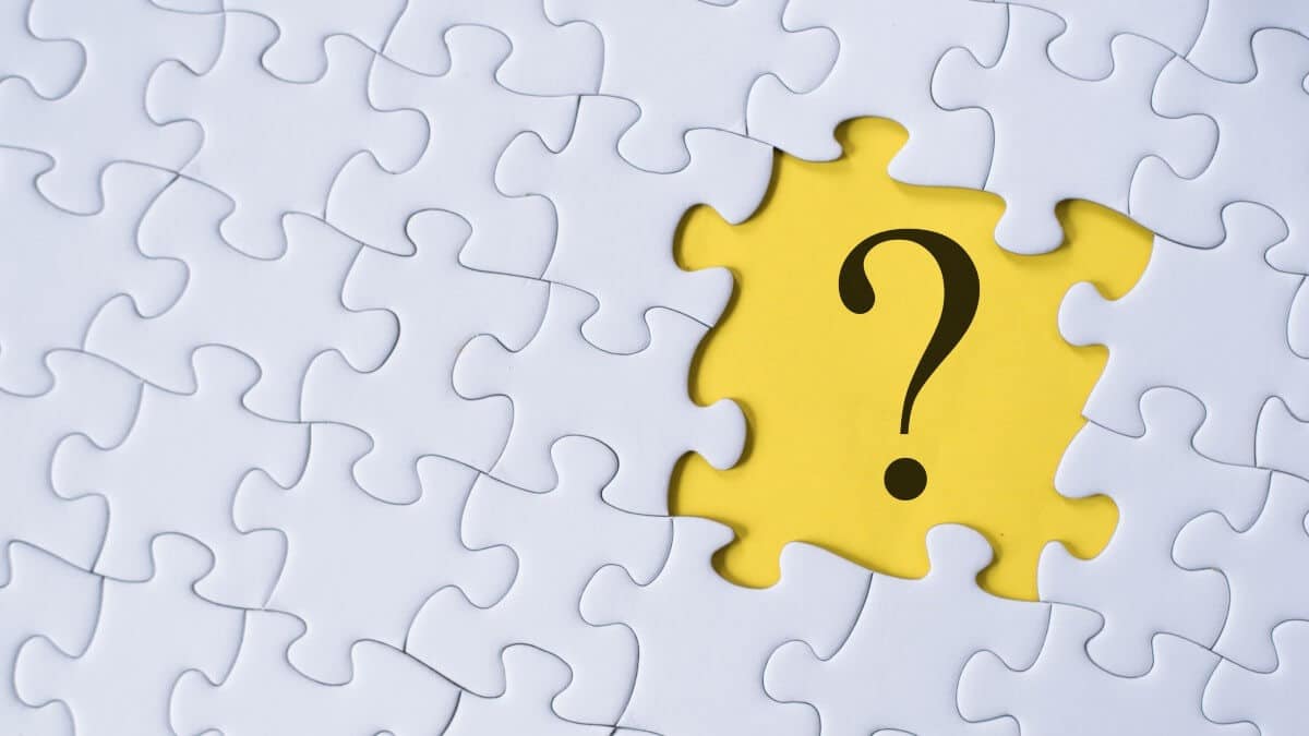 Question mark on jigsaw puzzle with yellow background.