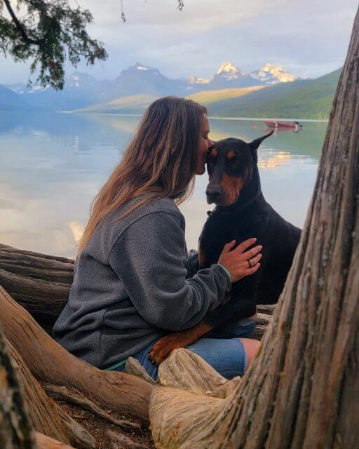 Cheyenne Calvert with a Doberman Pinscher on a lake