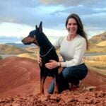 Cheyenne Calvert with a Doberman Pinscher on a hill