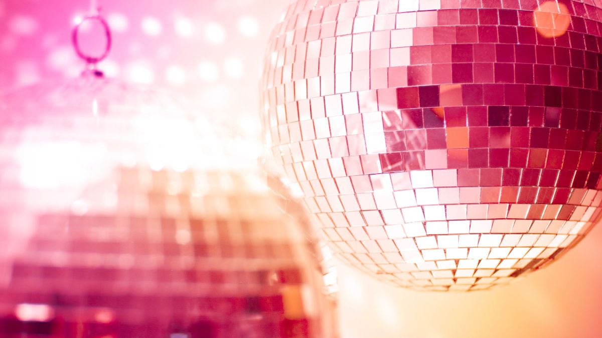 Orange mirror disco globes reflecting bright light.