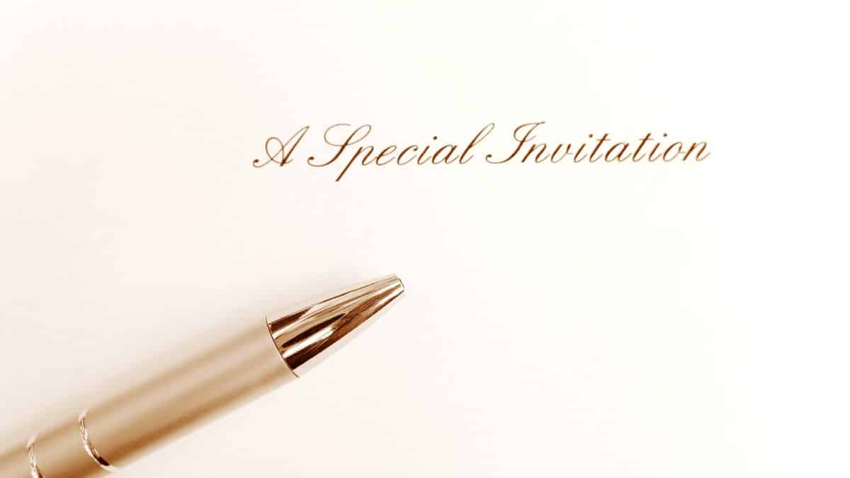 A special invitation card. you are invited. You re invited! A photograph showing a card with the words Special Invitation printed on it, taken with a golden pen beside it. Simple and elegant composition for the concept of writing a special invite. Vertical format photo.