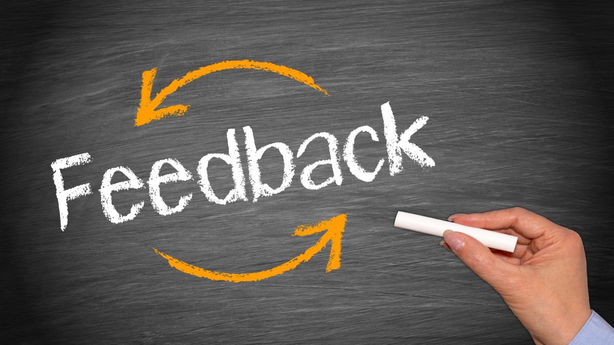 Hand drawing a conceptual illustration of business feedback on a blackboard.
